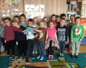 Dzieci z grupy V trzymają w rękach certyfikat adopcji słonia indyjskiego