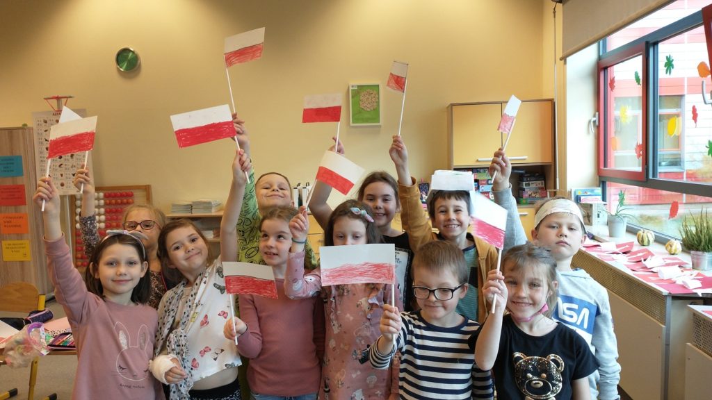 Uczniowie z wykonanymi przez siebie flagami Polski