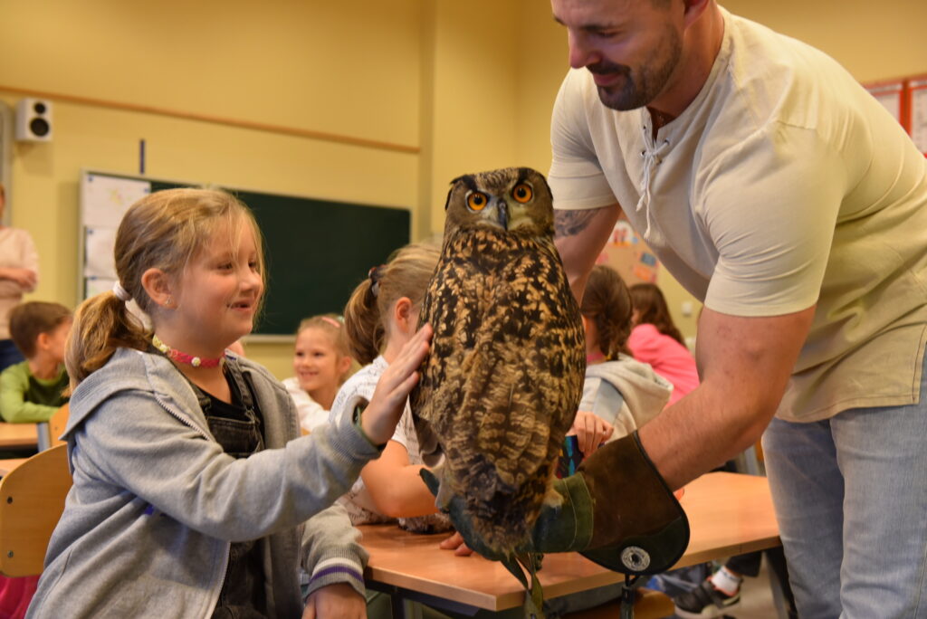 Uczennica klasy 2a głaszcze sowę.