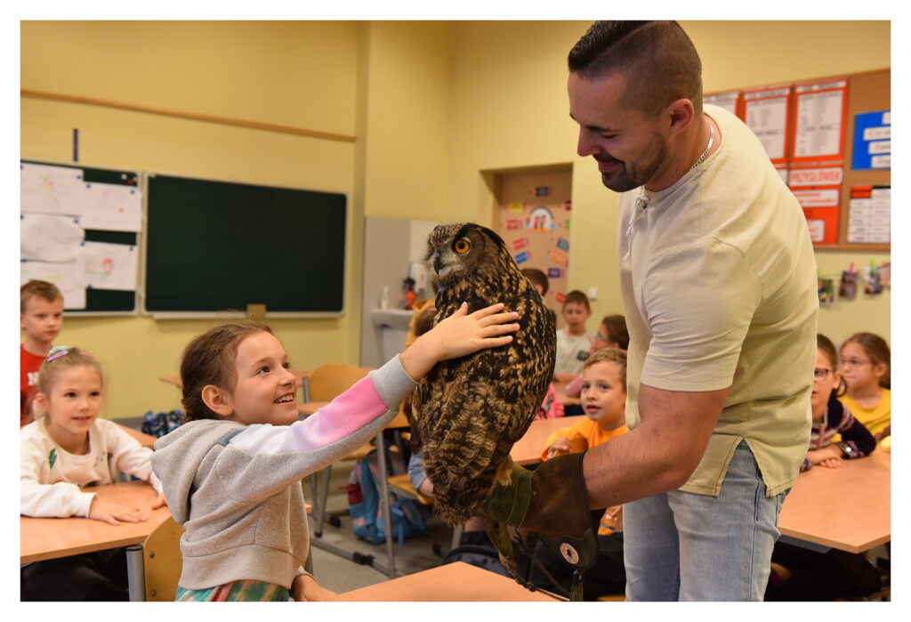 Uczennica klasy 2a głaszcze sowę.