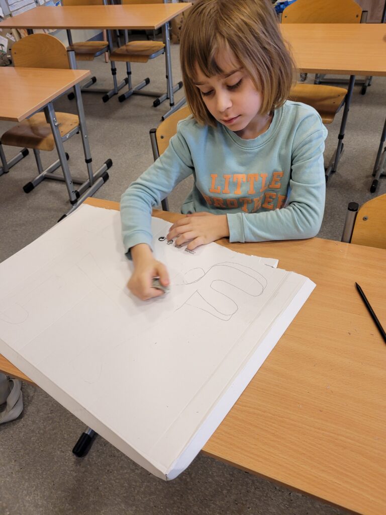 Uczeń szkicuje dinozaura