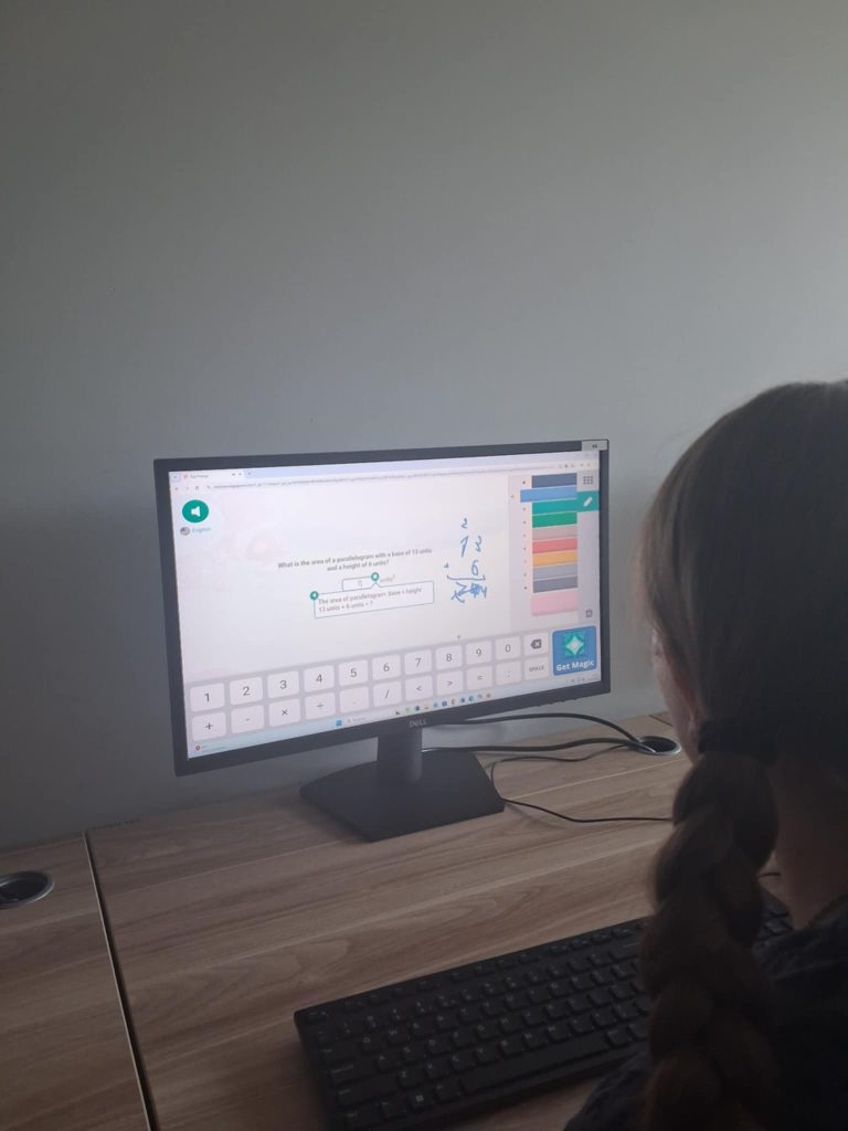 Klasa 6C rozwiązuje zadanie na liczenie pola przy użyciu mnożenia pisemnego