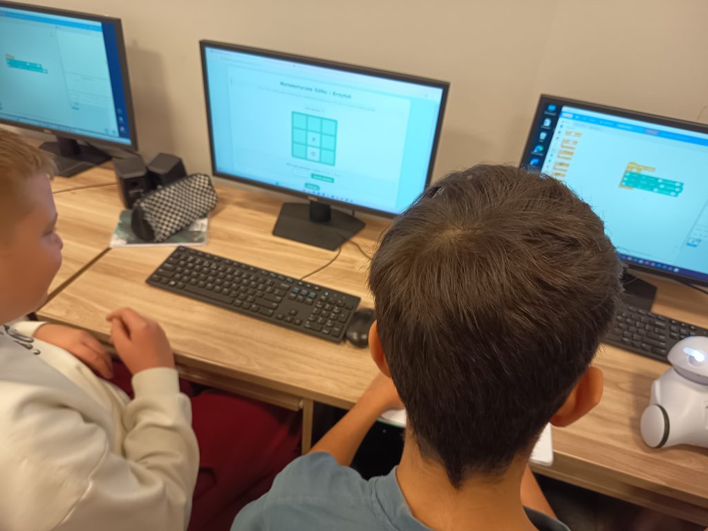 Szóstoklasiści grający w matematyczne „kółko i krzyżyk” z zadaniami wymagającymi obliczania pola prostokąta