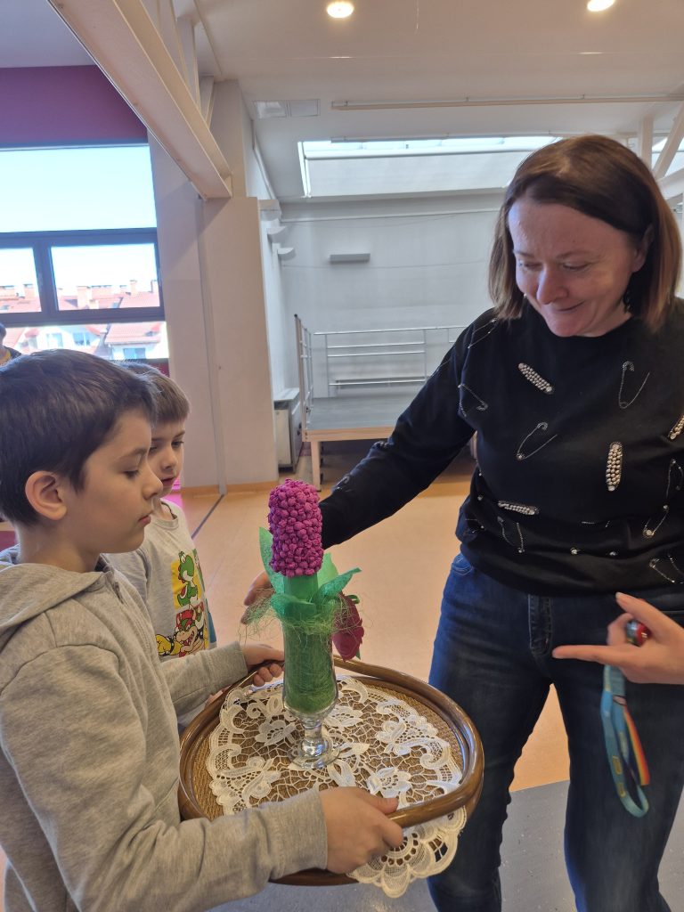 Pani Wicedyrektor Anna Wasiak odbiera upominek od chłopców.