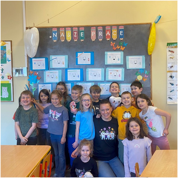 Dzieci z grupy III świetlicowej na wspólnym zdjęciu z panią Marzenką – asystentką stomatologiczną