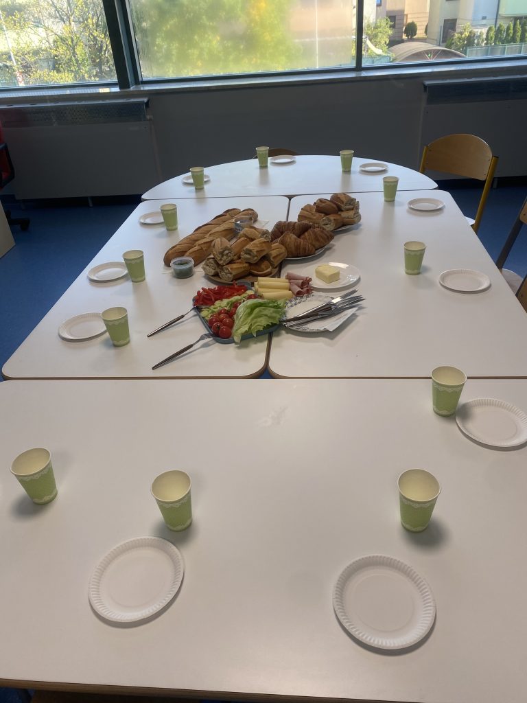 Francuskie śniadanie - stół z pysznymi bagietkami, croissantami oraz talerzem warzyw i zdrowych dodatków.